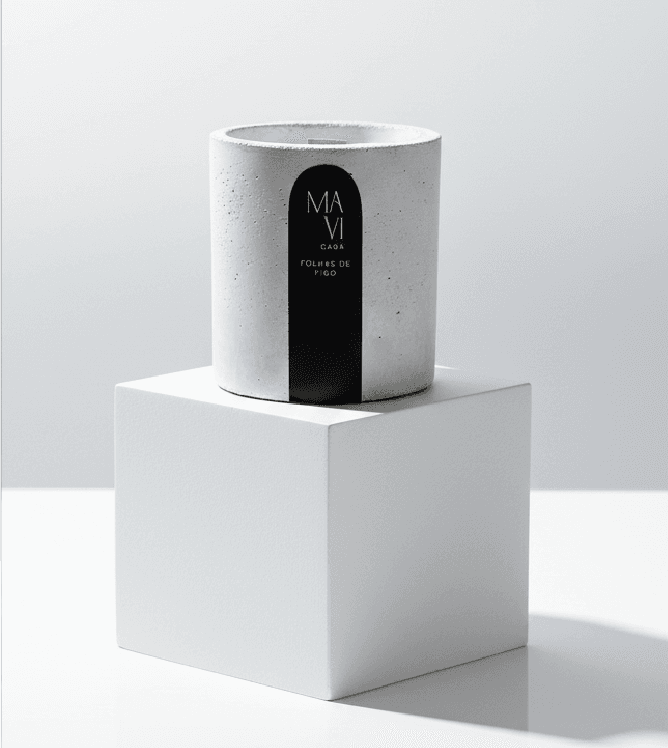 Vela vegetal Mavi Casa em pote de concreto sobre um pedestal branco no ateliê